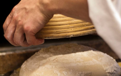 Chefs hands turning out bread dough from a basket